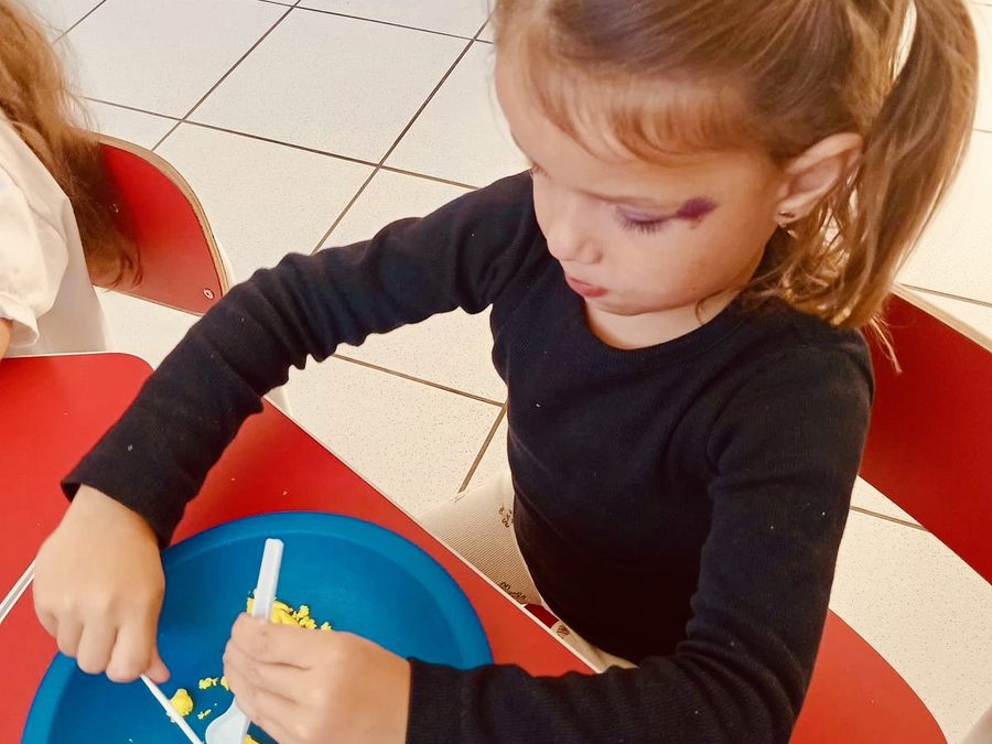 Criança brincando com massinha e talheres